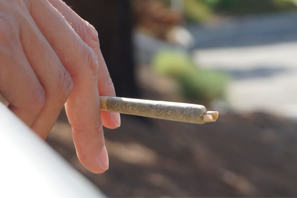 A person smoking cannabis in an outdoor cannabis consumption space