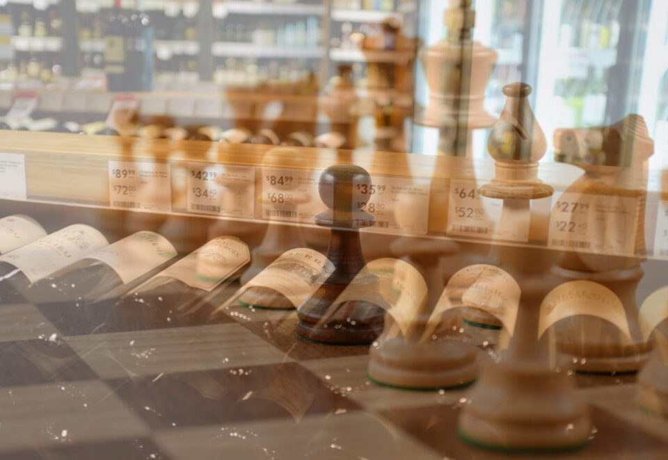 Wine bottles and superimposed chess pieces as a visual metaphor for liquor store strategic planning