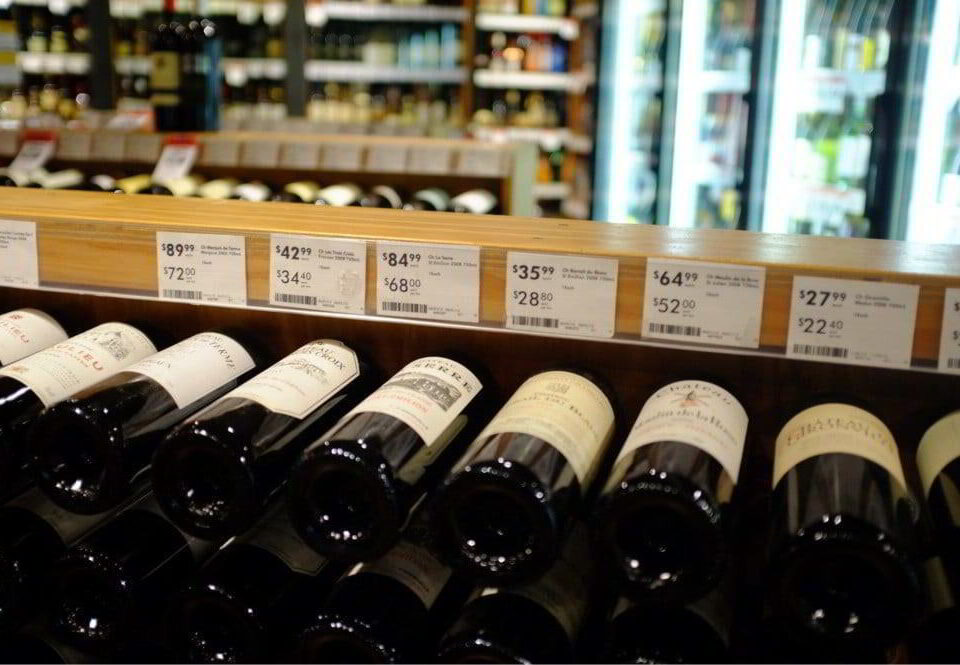 Liquor store interior showing wine on racks and beer in fridges